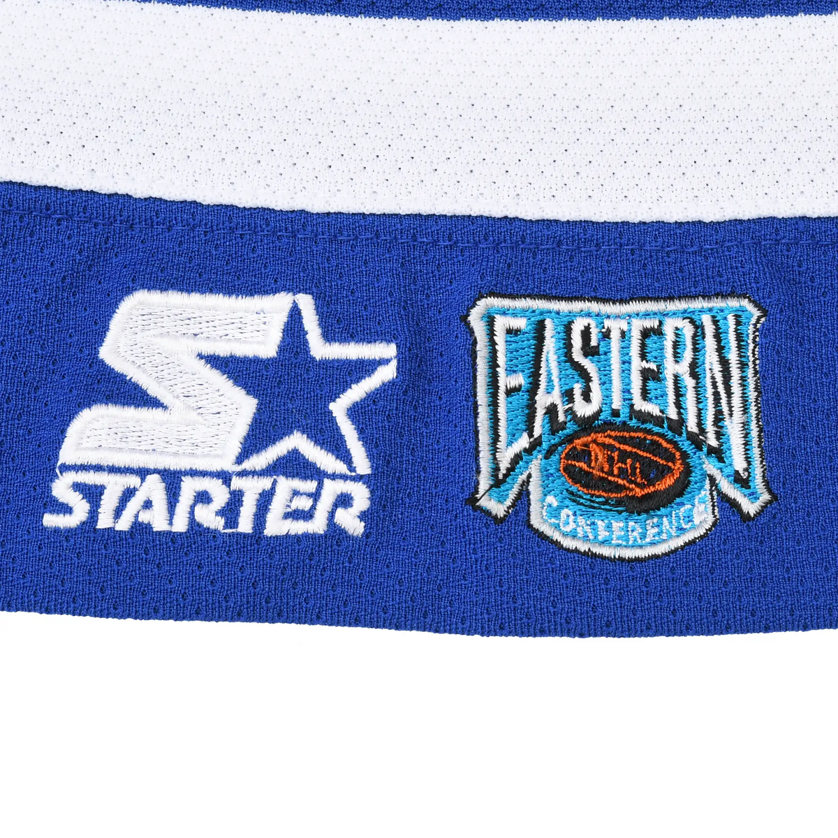 Close-up of embroidered Starter and NHL Eastern Conference logos at jersey hem