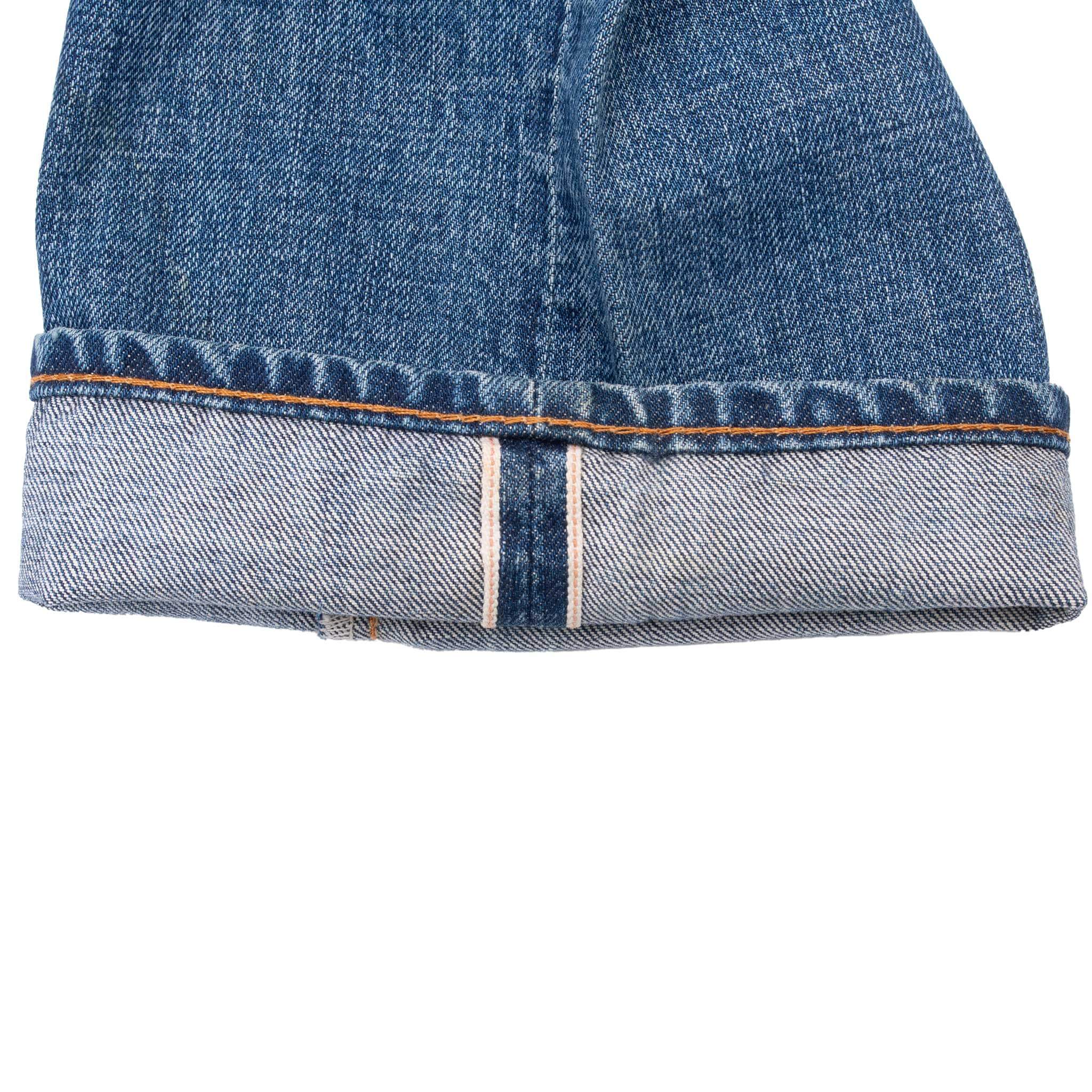 Cuffed jean hem showing red line selvedge detail and orange stitching