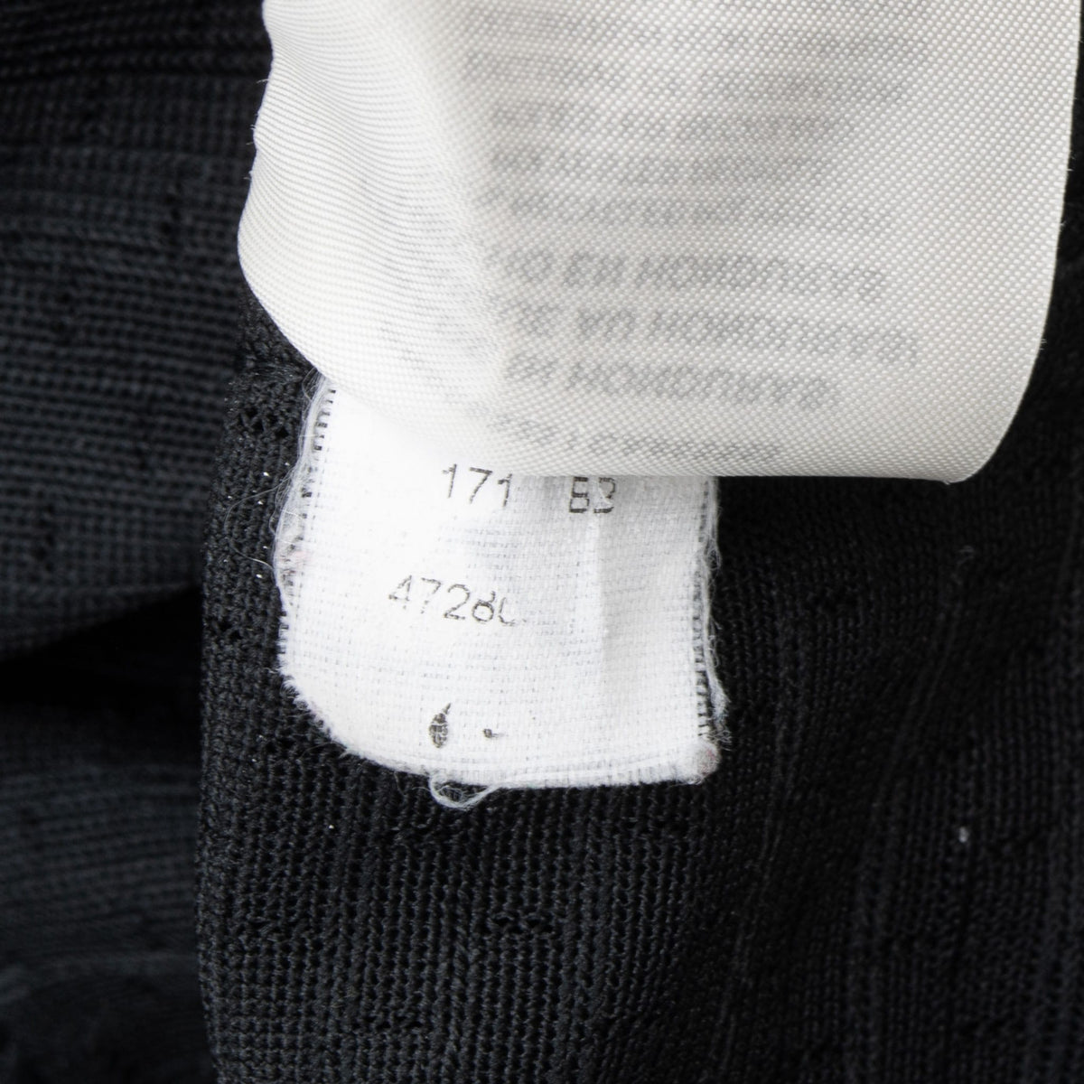 Close-up of faded interior care labels on the black jersey
