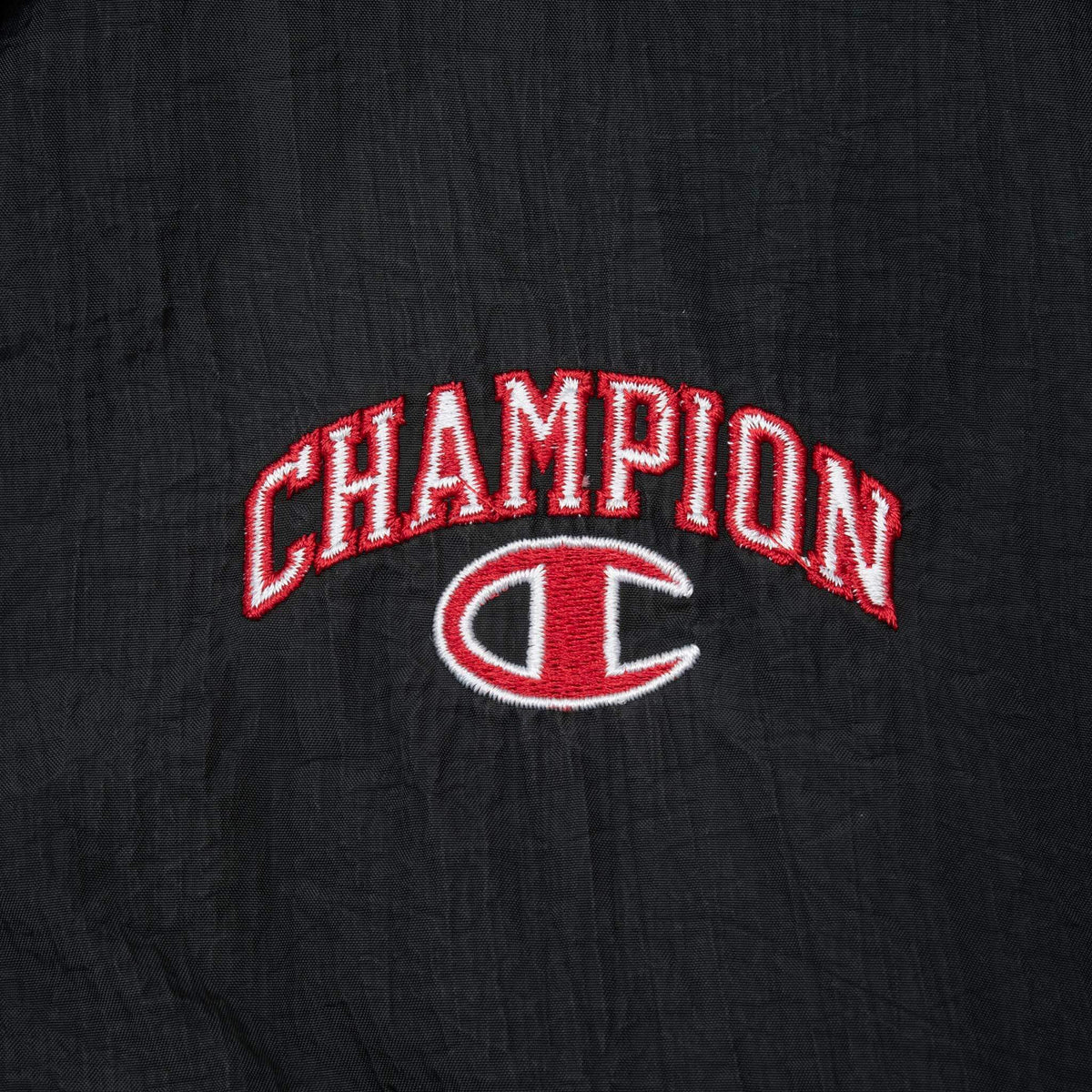 Red and white Champion logo embroidery on black jacket chest