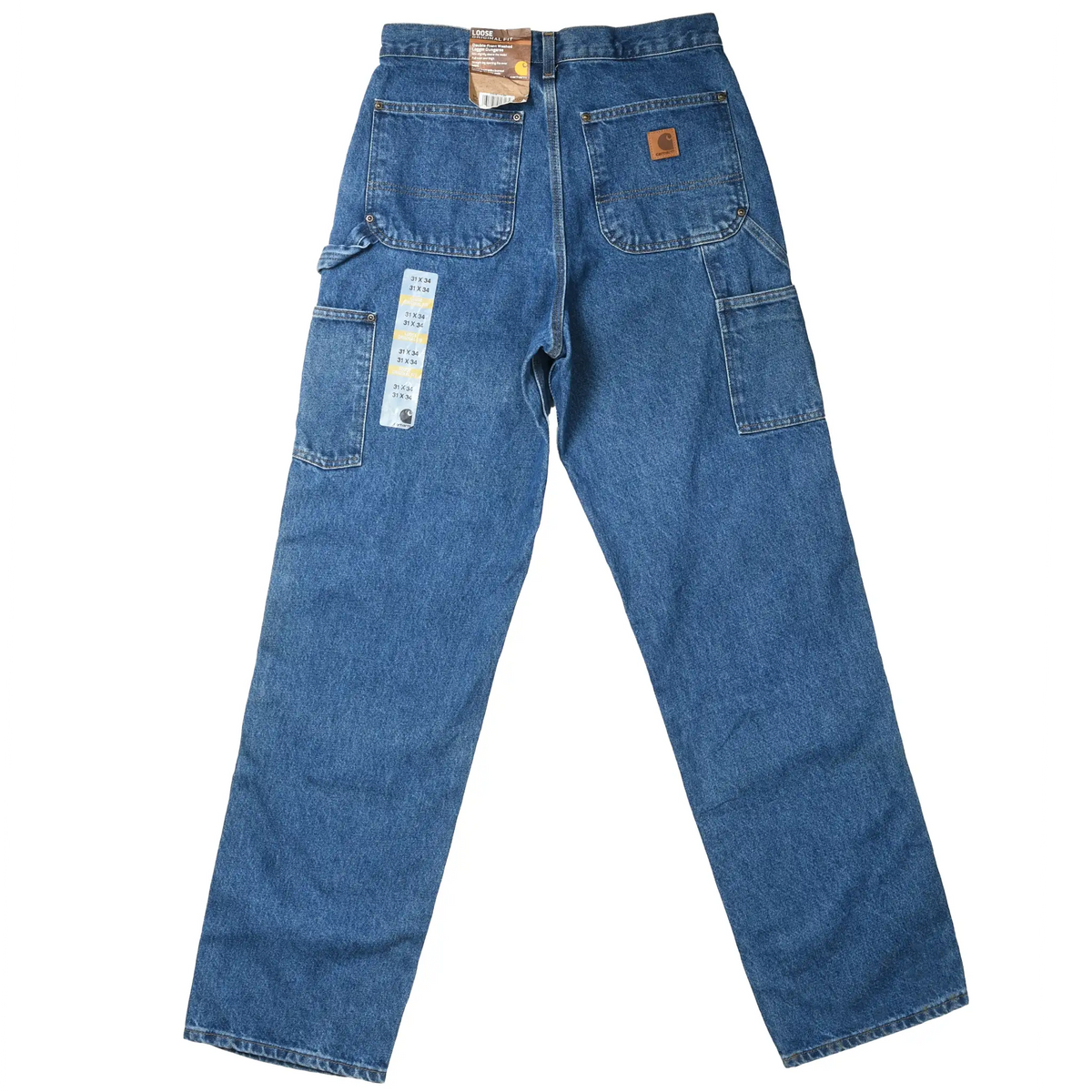 Back of Carhartt blue carpenter jeans with patch pockets, utility pockets, tags, and logo patch