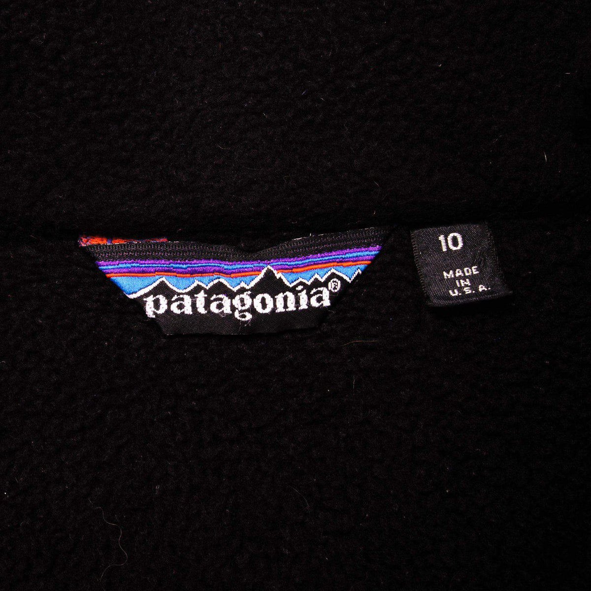 Patagonia neck label and size 10 Made in USA tag on black fabric