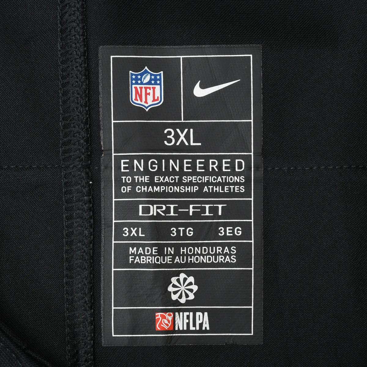 Close-up of Nike NFL Dri-FIT 3XL interior label on black jersey fabric