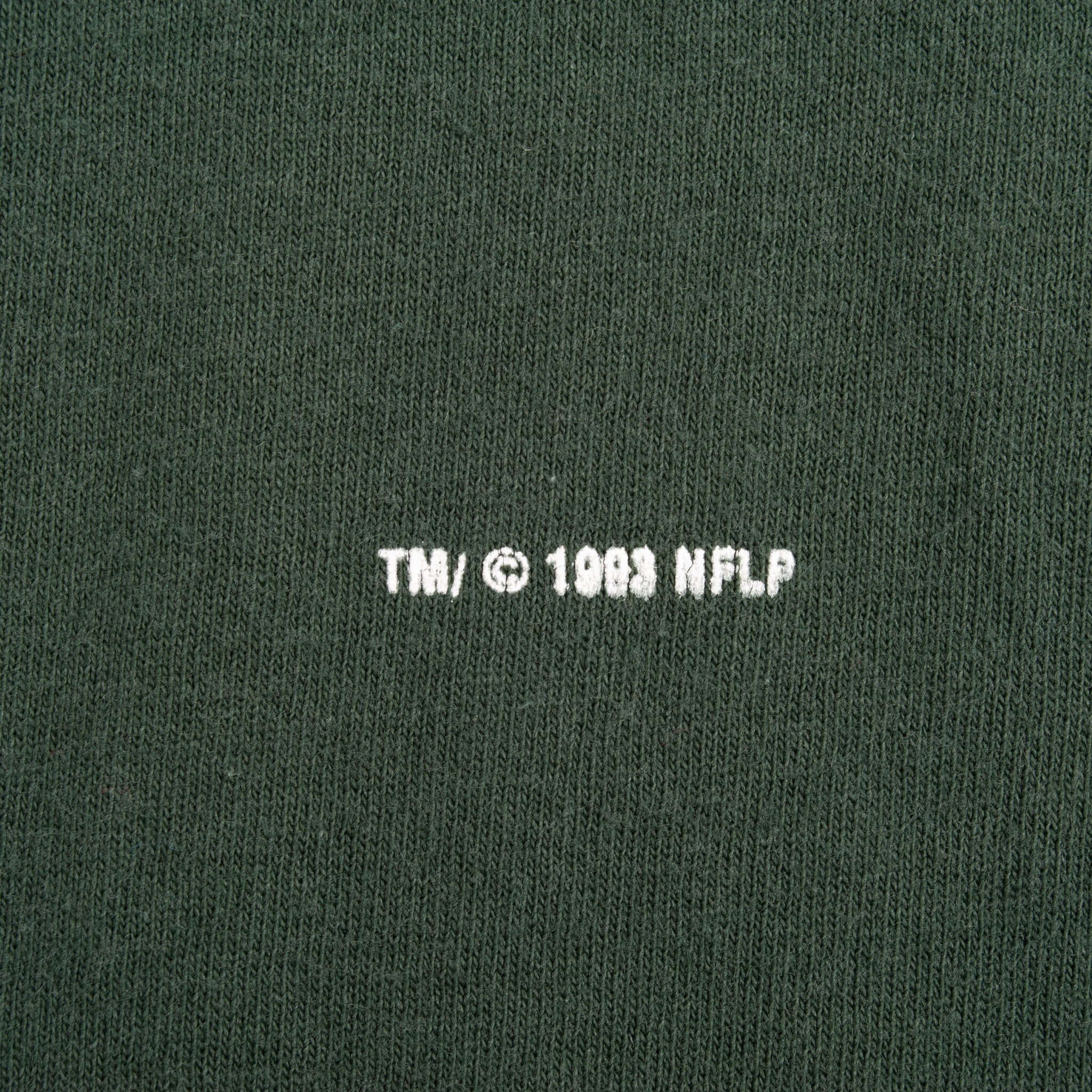 Close-up of TM and 1993 NFLP copyright print on dark green fabric