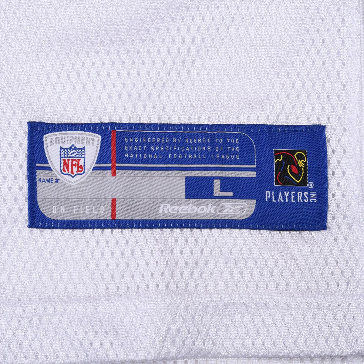Close-up of Reebok NFL Players jersey hem label on white mesh fabric