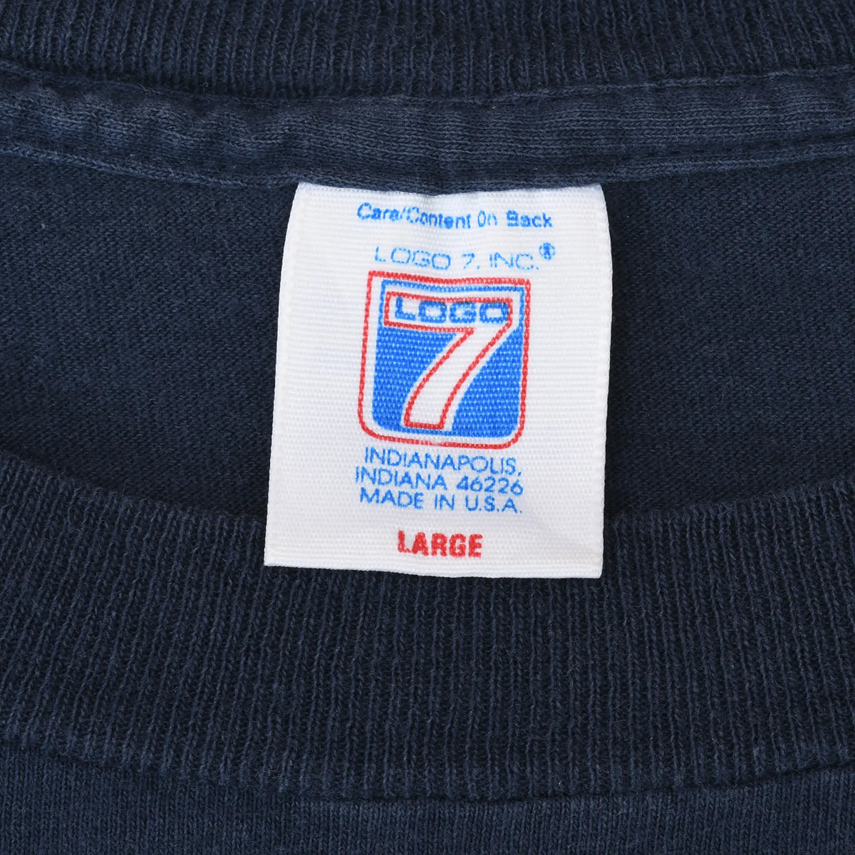 Close-up of Logo 7 neck tag marked large and Made in U.S.A. on navy fabric