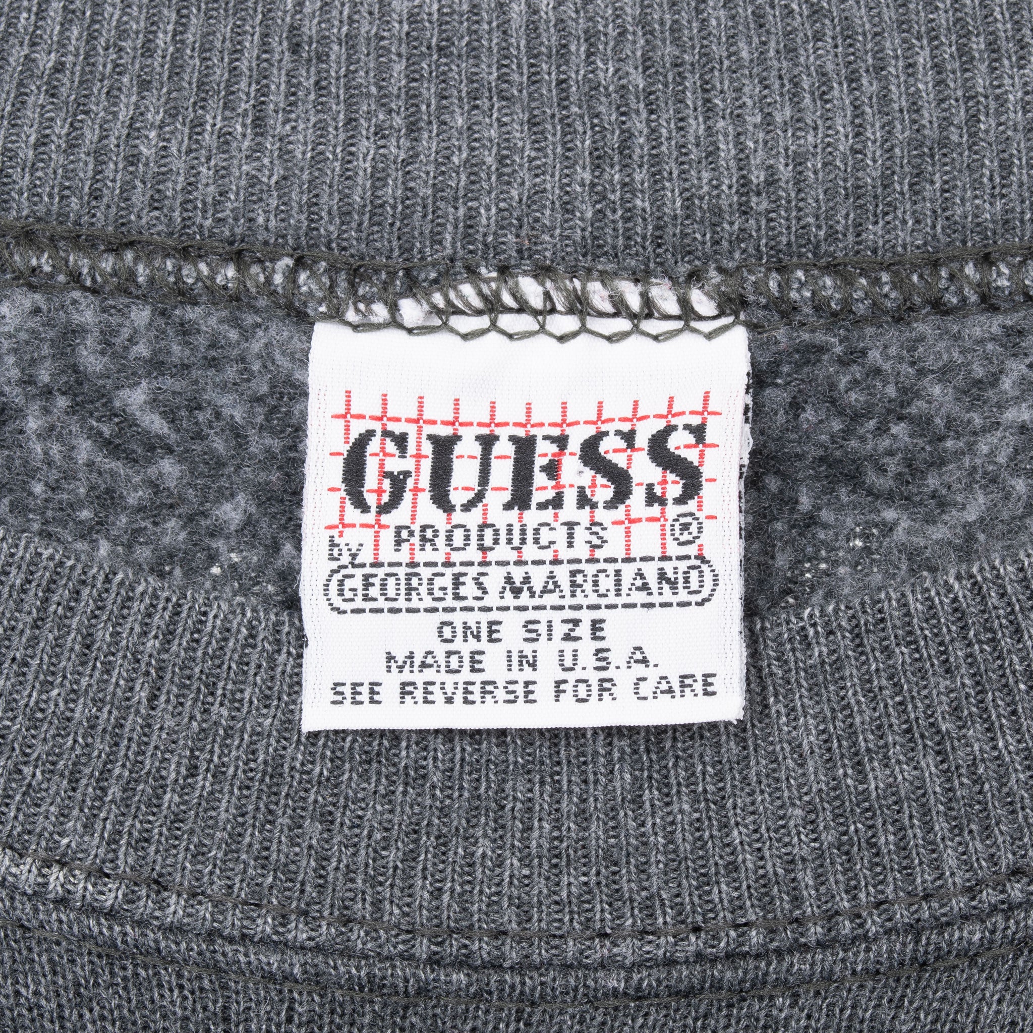 Close-up of Guess Products neck label inside grey crewneck sweatshirt