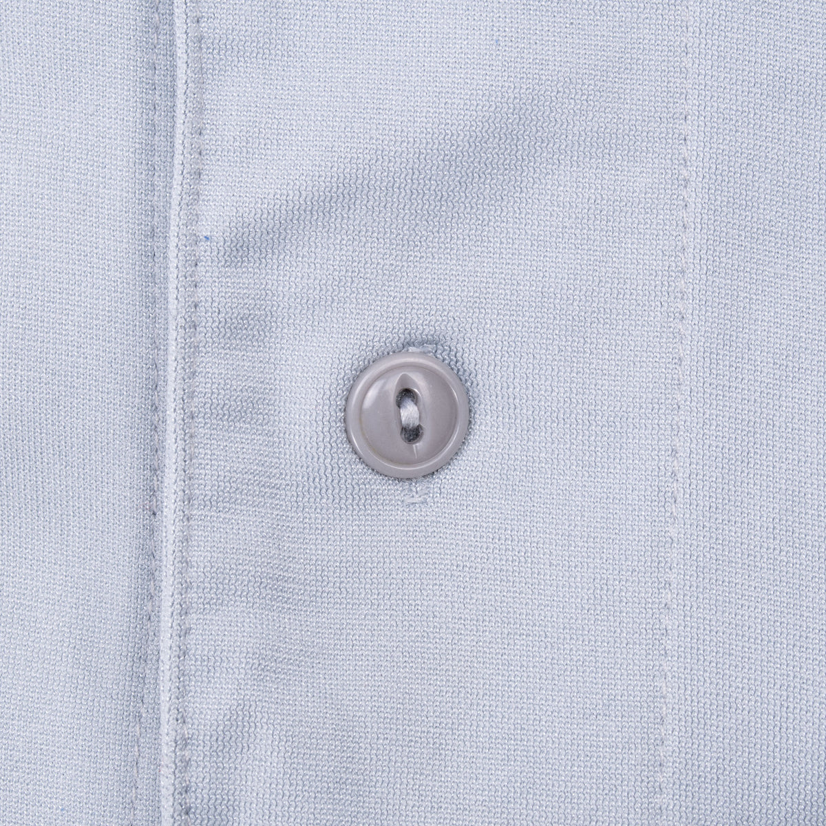 Close-up of gray jersey fabric, front seam, and button
