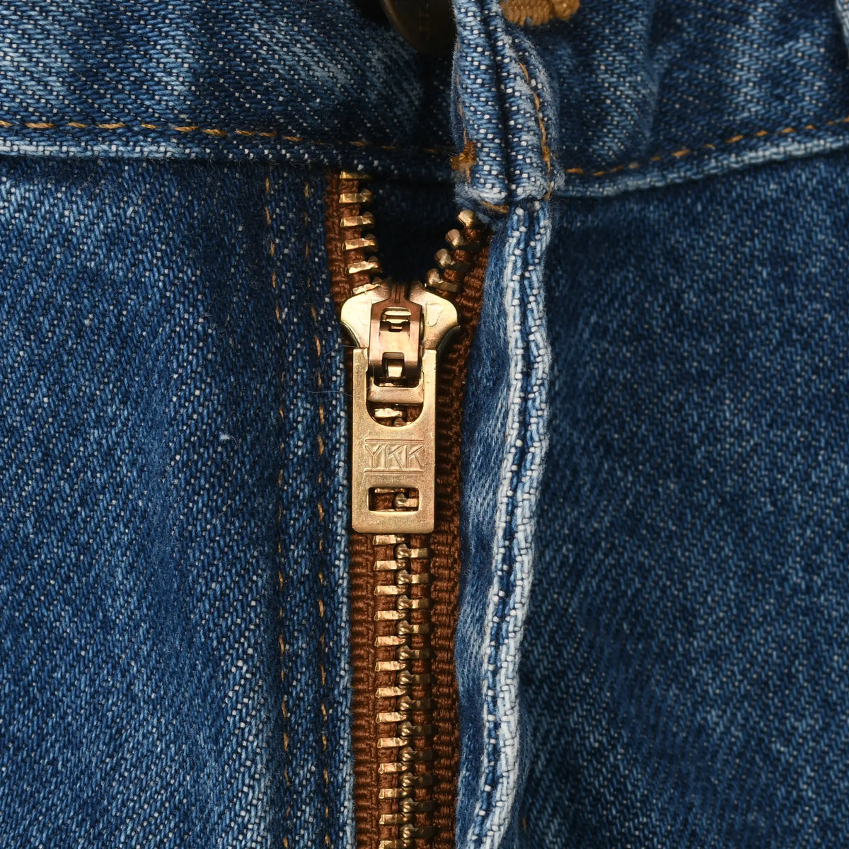 Close-up of brass YKK zipper fly on blue Carhartt jeans