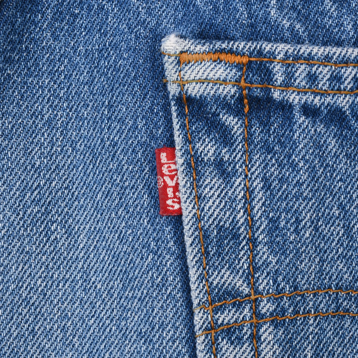Close-up of red Levi's tab beside a back pocket seam on blue jeans