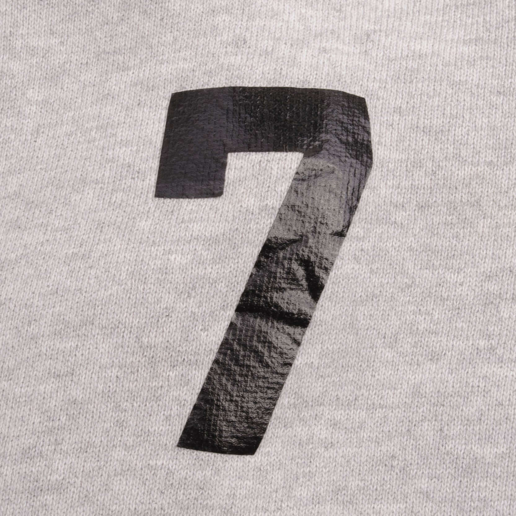 Close-up of black number 7 print on gray hoodie sleeve