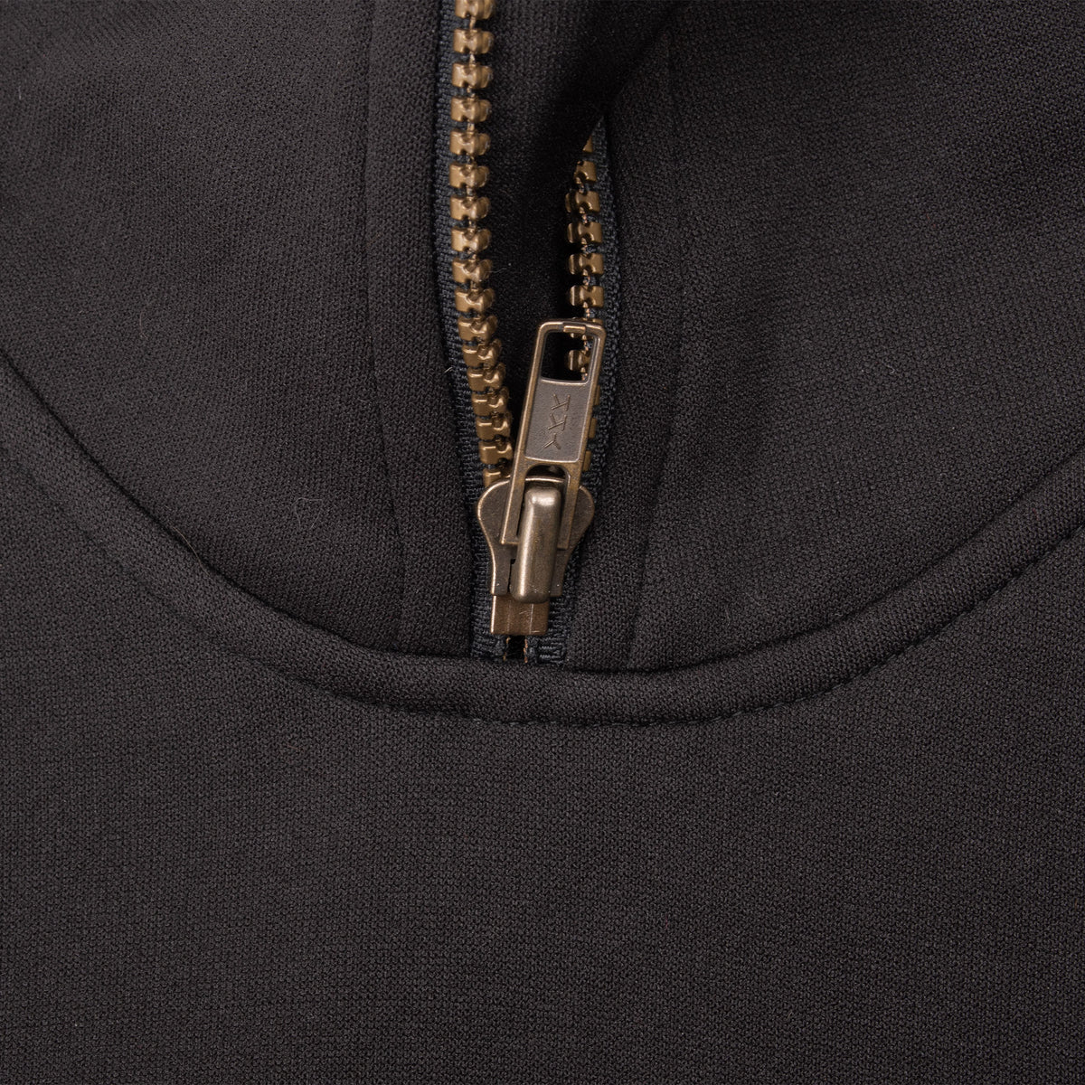 Close-up of metal quarter-zip closure on black Adidas Equipment track jacket