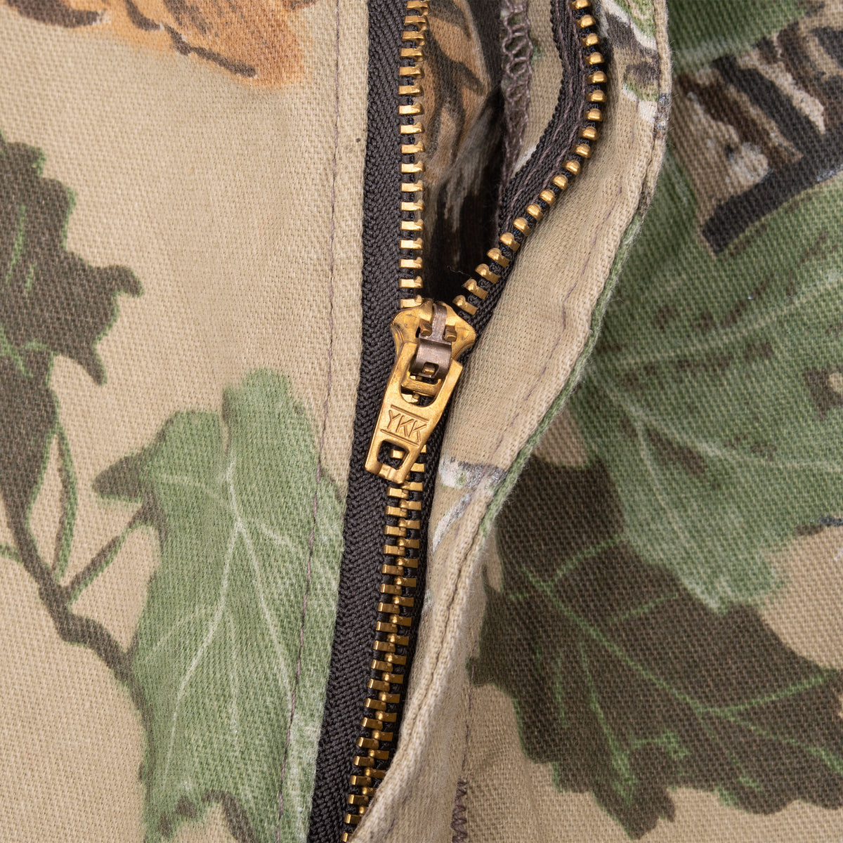 Close-up of brass-tone YKK zipper fly on Realtree camouflage cargo pants