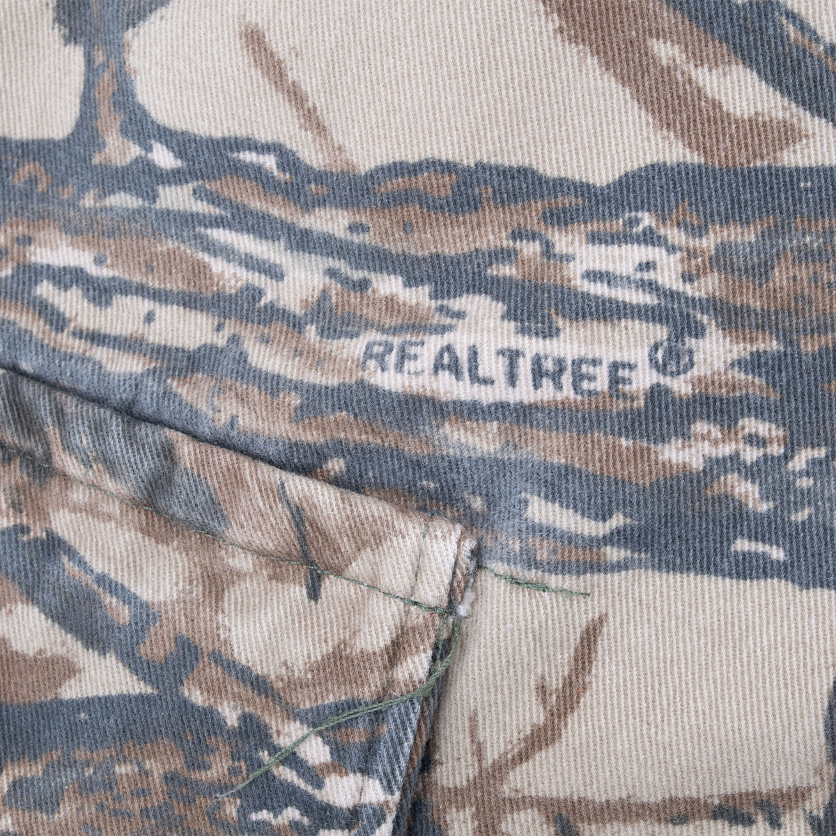 Close-up of Realtree logo print and pocket seam on camouflage pants