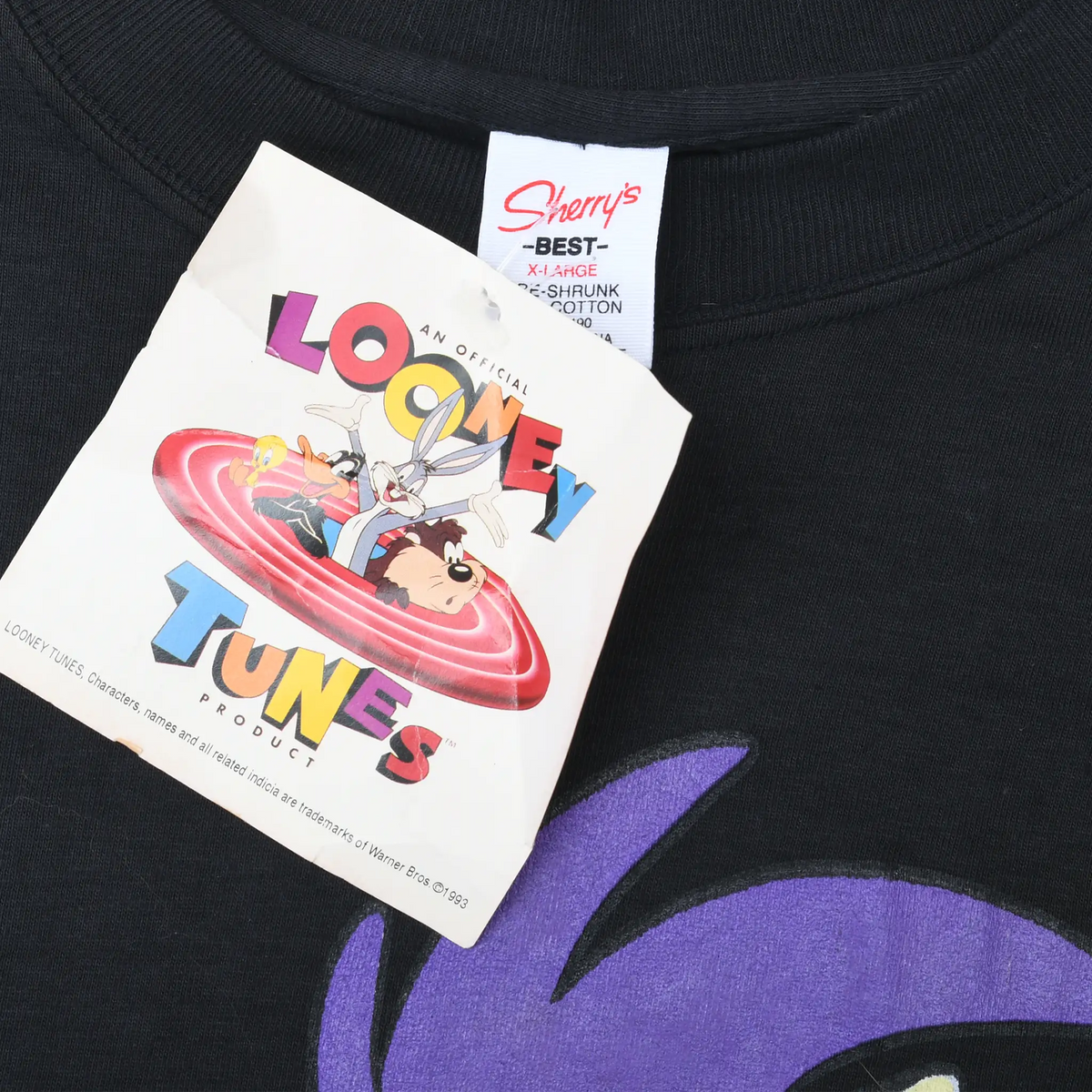 Close-up of Looney Tunes hangtag and Sherry's Best neck label on black T-shirt