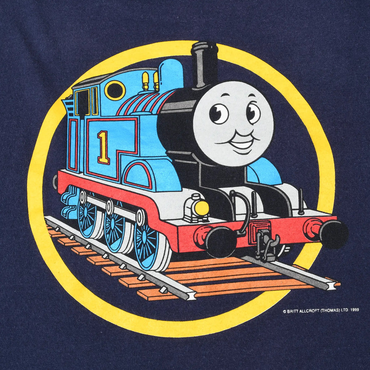 Close-up of back graphic showing Thomas the Tank Engine on rails within a yellow circle