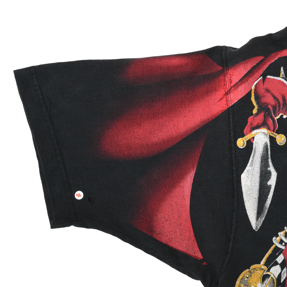 Close-up of black sleeve with red cape print and a small hole near the lower left