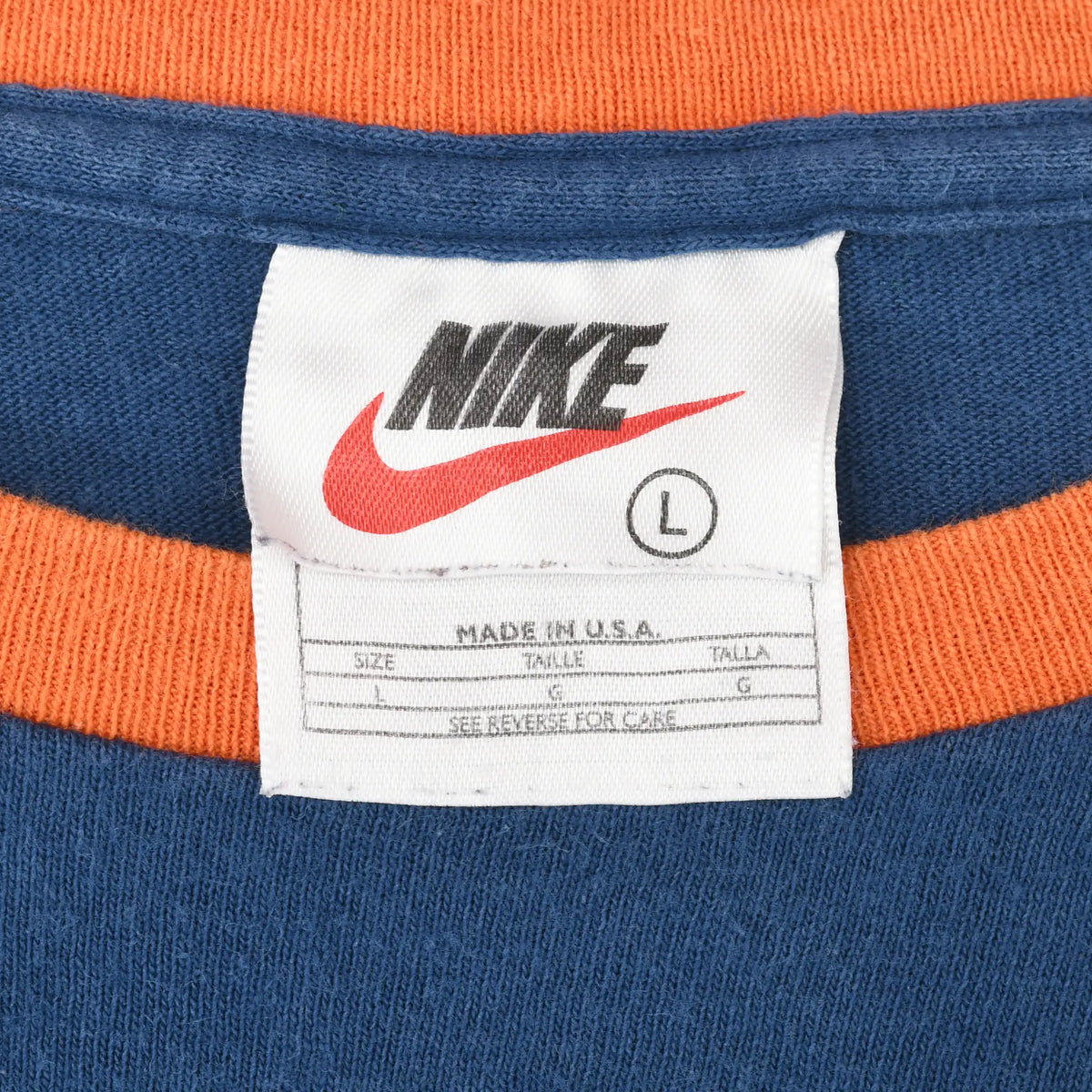 Nike neck tag marked size L and Made in USA inside blue shirt with orange collar