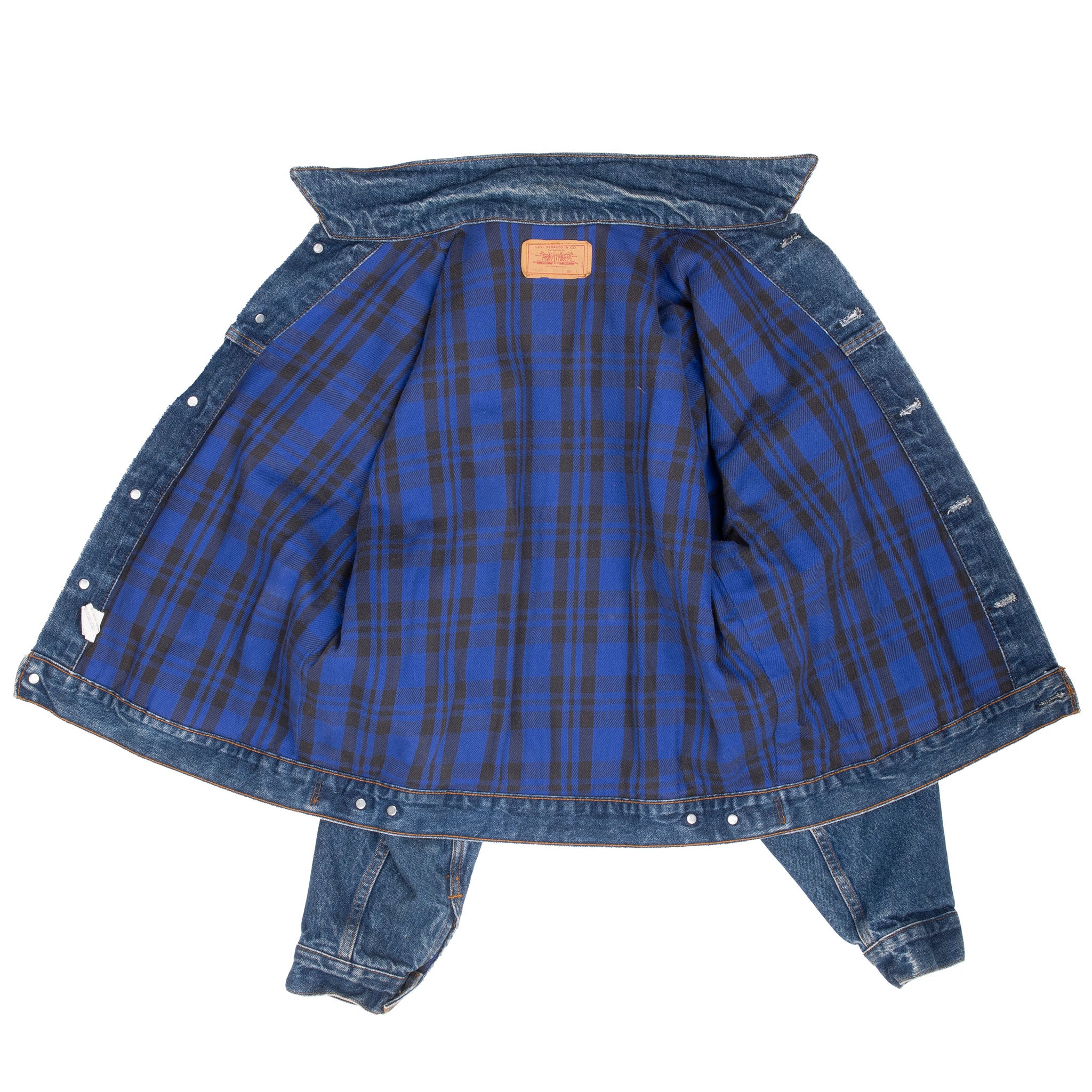 Levi's denim trucker jacket opened to show blue and black plaid lining