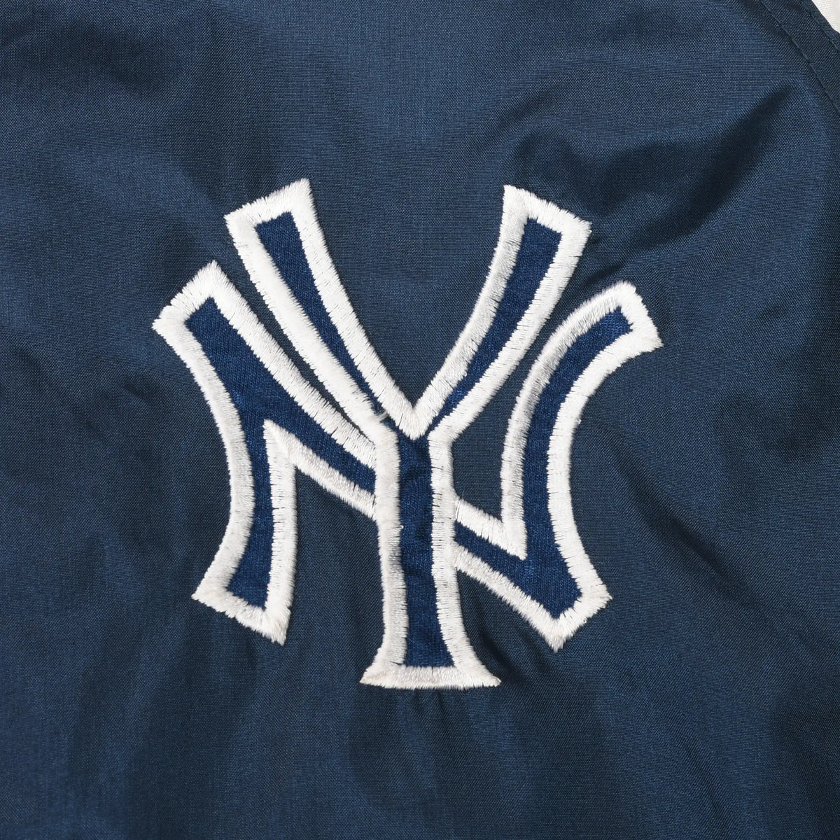 Close-up of white outlined New York Yankees NY logo embroidery on navy fabric