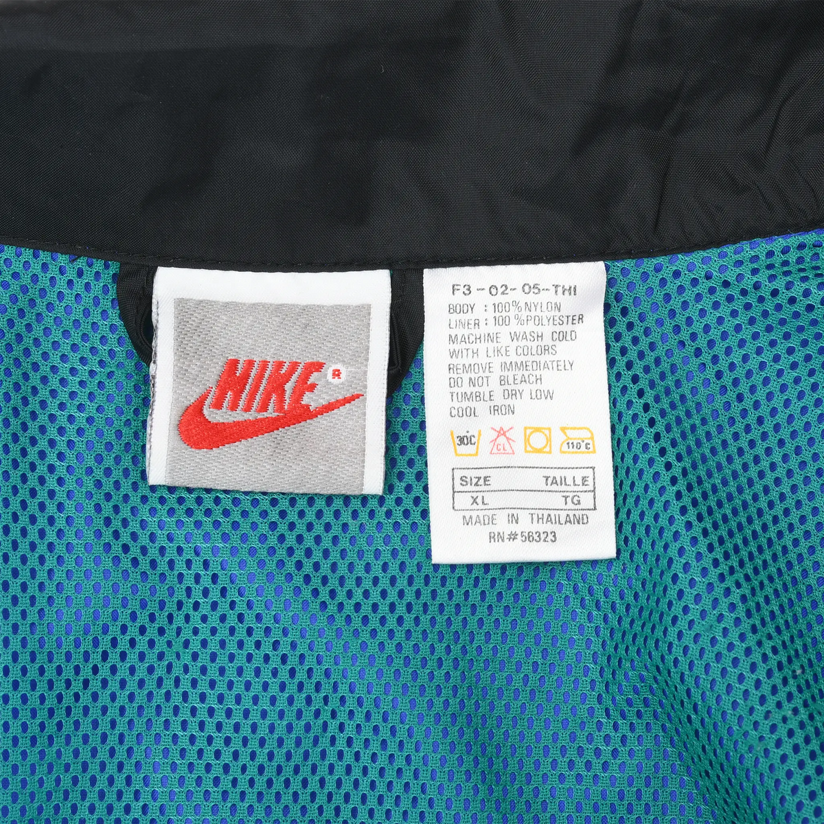Close-up of Nike neck and care labels marked size XL against teal mesh lining