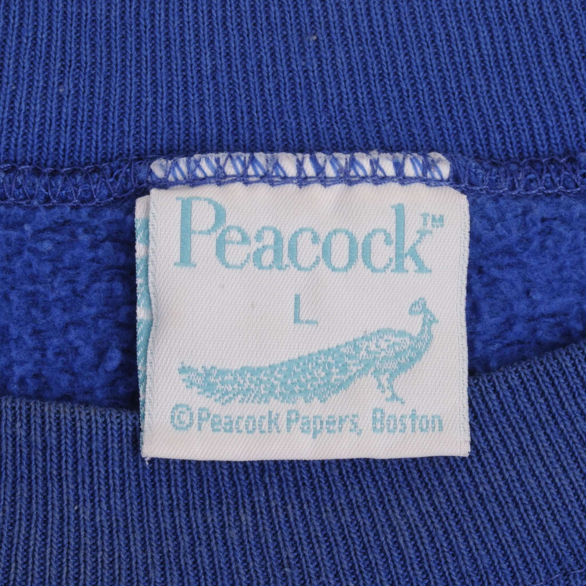Peacock neck label with size L and peacock logo inside blue sweatshirt