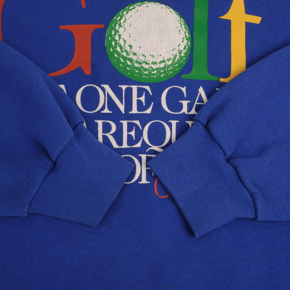 Close-up of blue ribbed sleeve cuffs laid over the sweatshirt's golf graphic