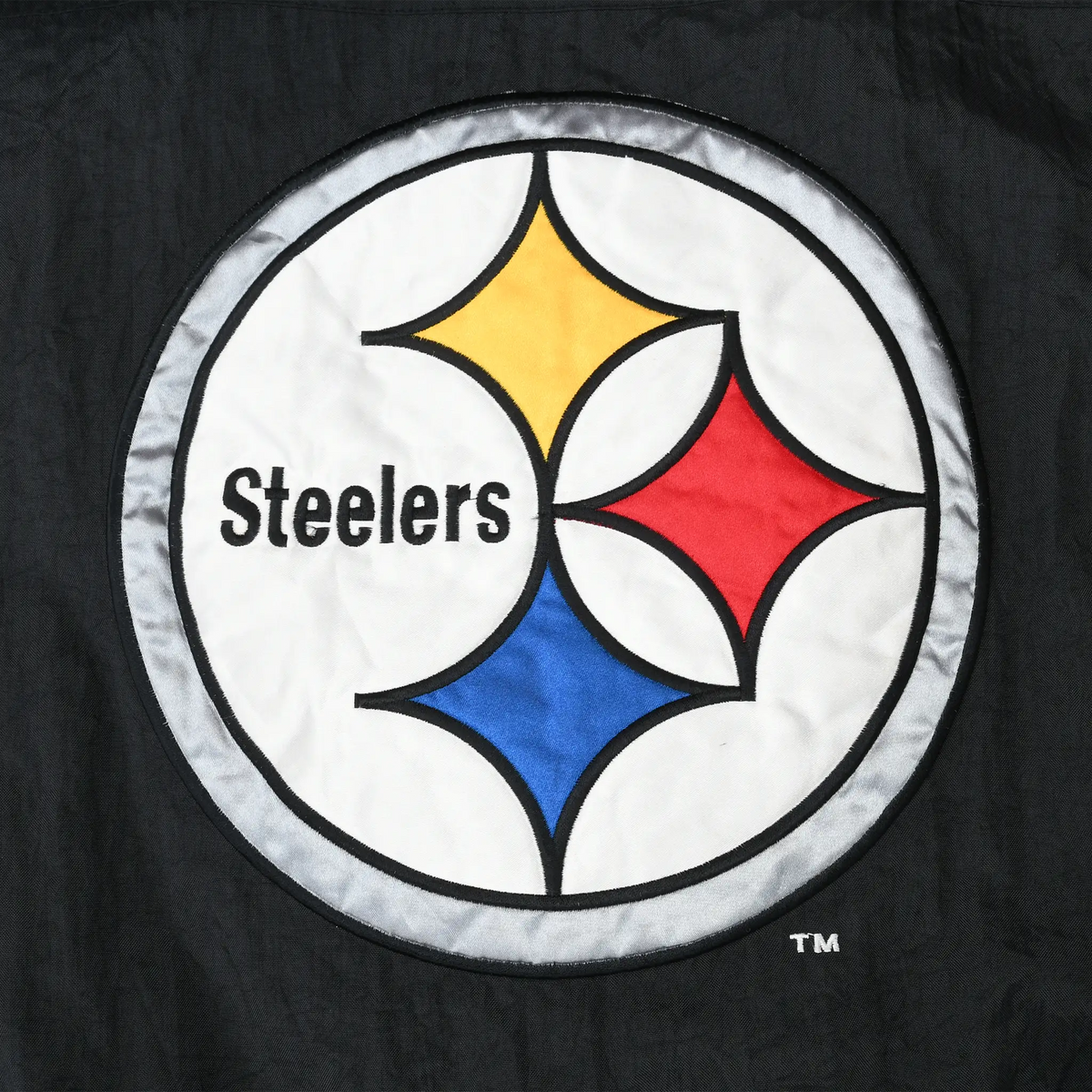 Close-up of large Pittsburgh Steelers logo patch on the back of the black jacket
