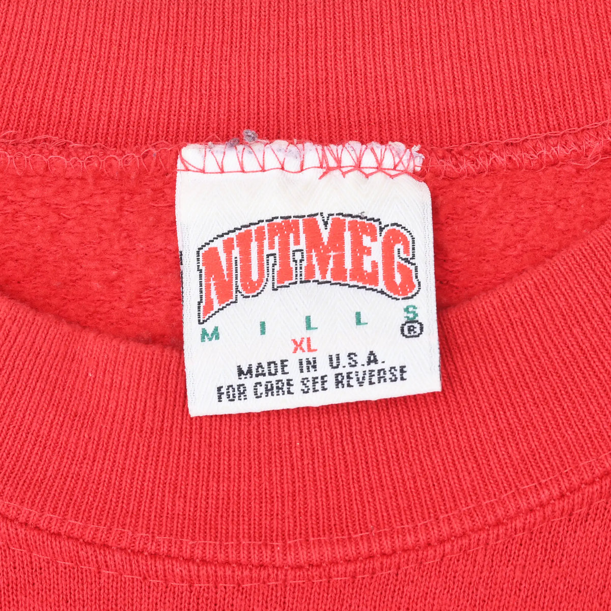 Close-up of Nutmeg Mills XL Made in USA neck label inside red sweatshirt