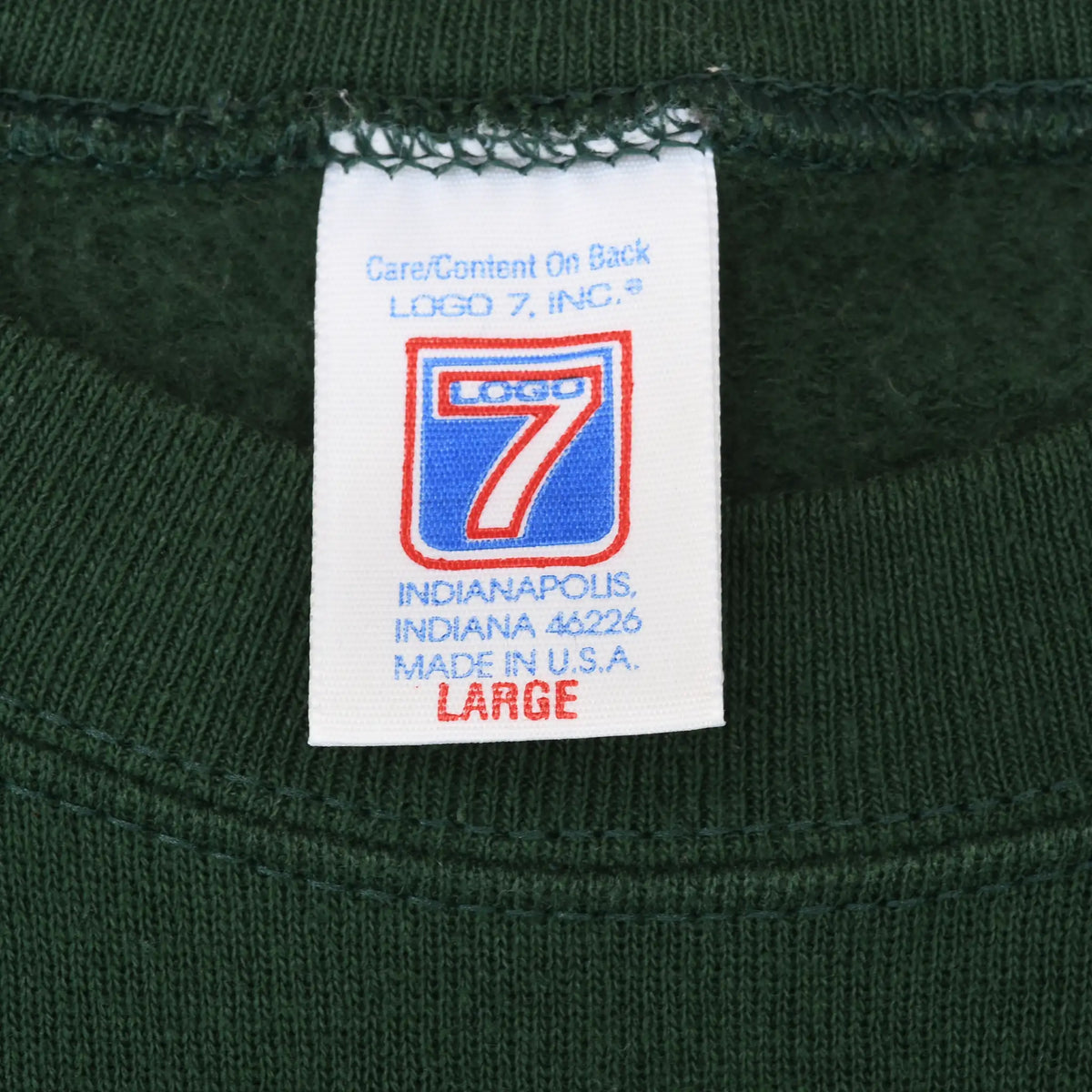 Close-up of Logo 7 neck label marked large and made in USA inside green sweatshirt