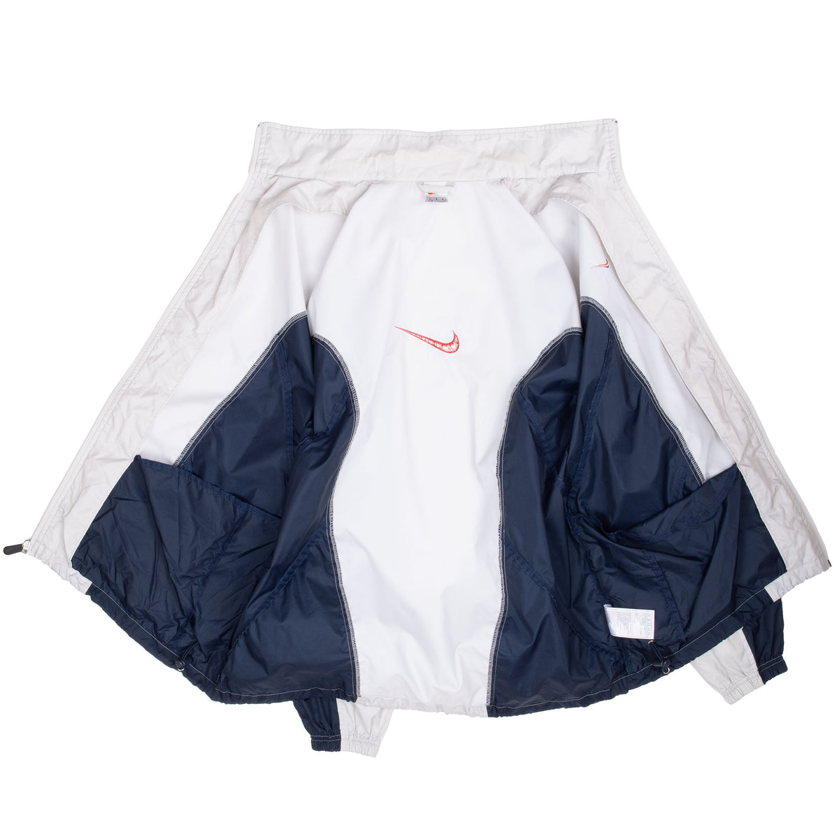 Interior view of open white and navy Nike windbreaker showing inner seams and panels