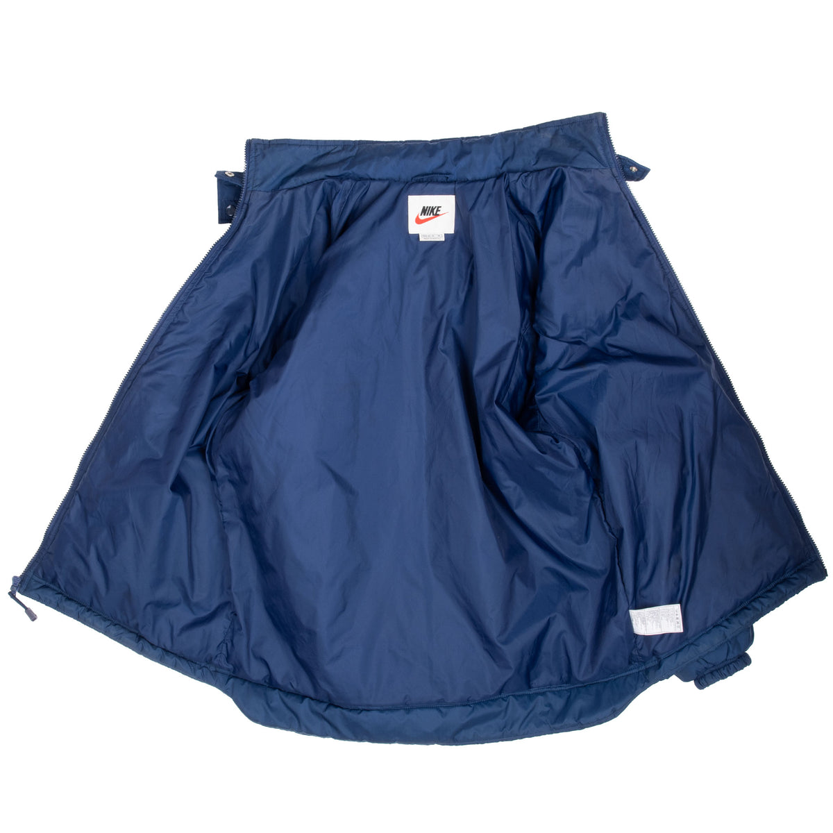 Open blue Nike women's puffer jacket showing the interior lining and labels
