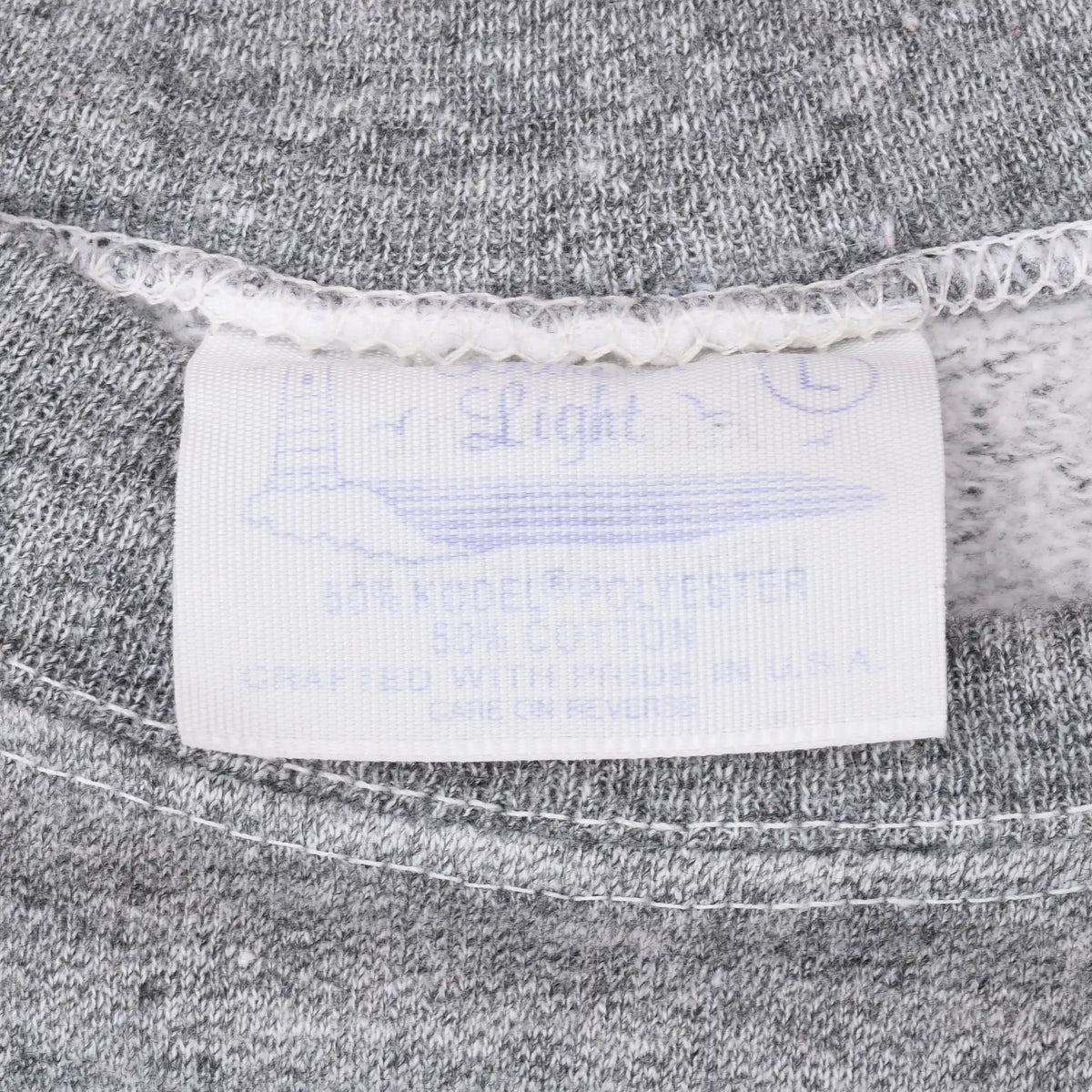 Close-up of faded neck label and stitching inside gray Disney sweatshirt