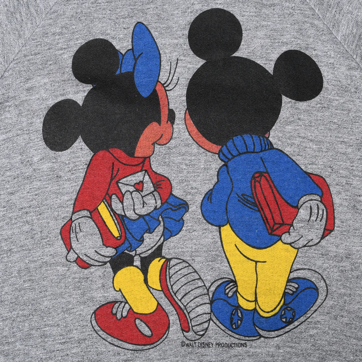 Close-up of back print showing Mickey and Minnie Mouse from behind with books