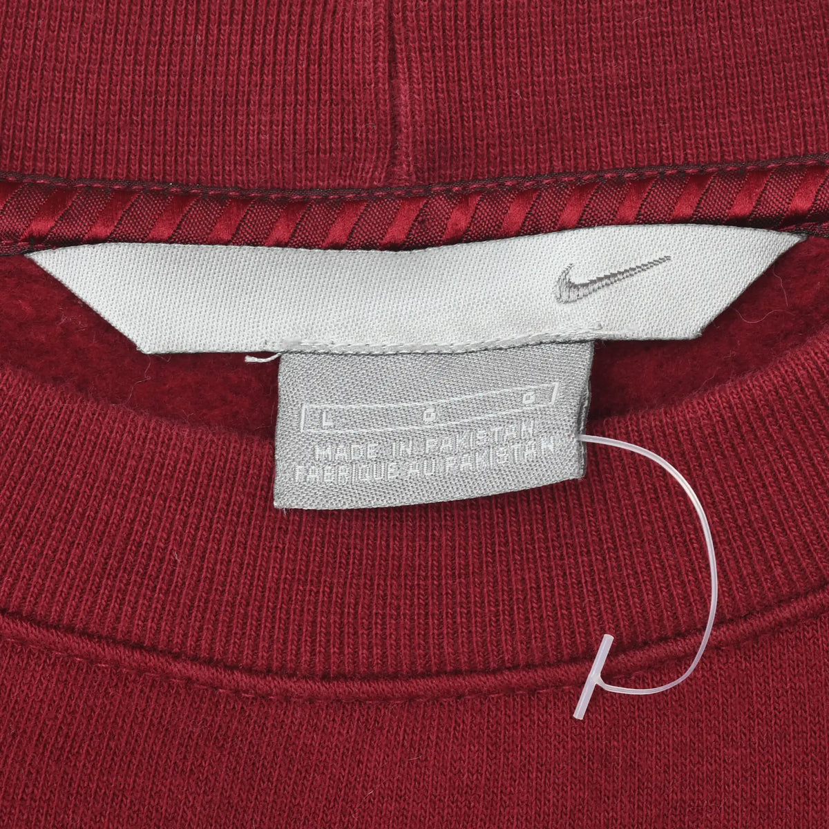 Close-up of Nike neck label and Swoosh detail inside burgundy sweatshirt collar