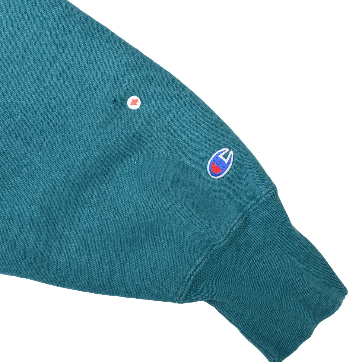 Teal sweatshirt sleeve detail with embroidered Champion logo near the ribbed cuff