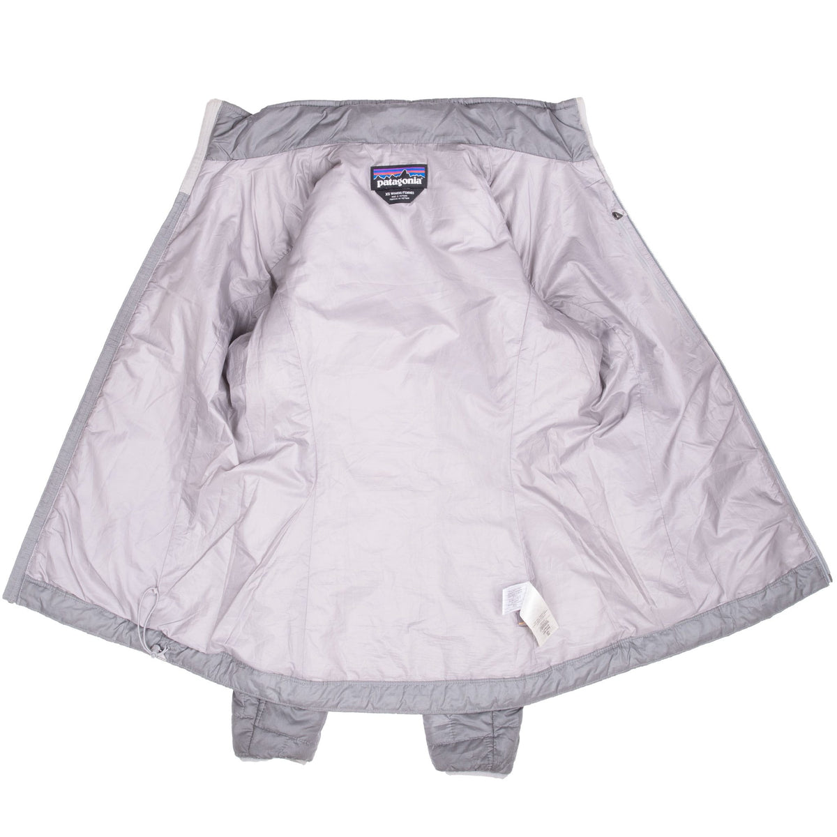 Open grey Patagonia Nano Puff jacket showing the light grey interior and labels