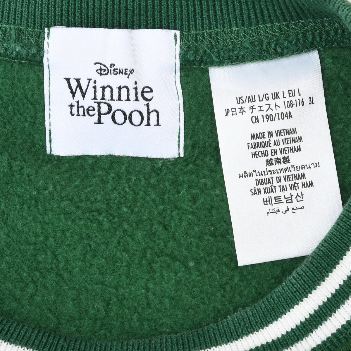 Close-up of Disney Winnie the Pooh neck label and large size tag inside green sweatshirt