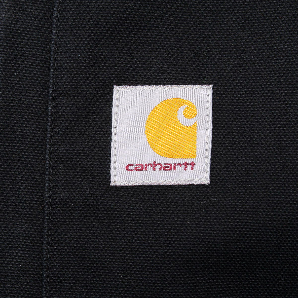 Close-up of Carhartt logo patch on black vest