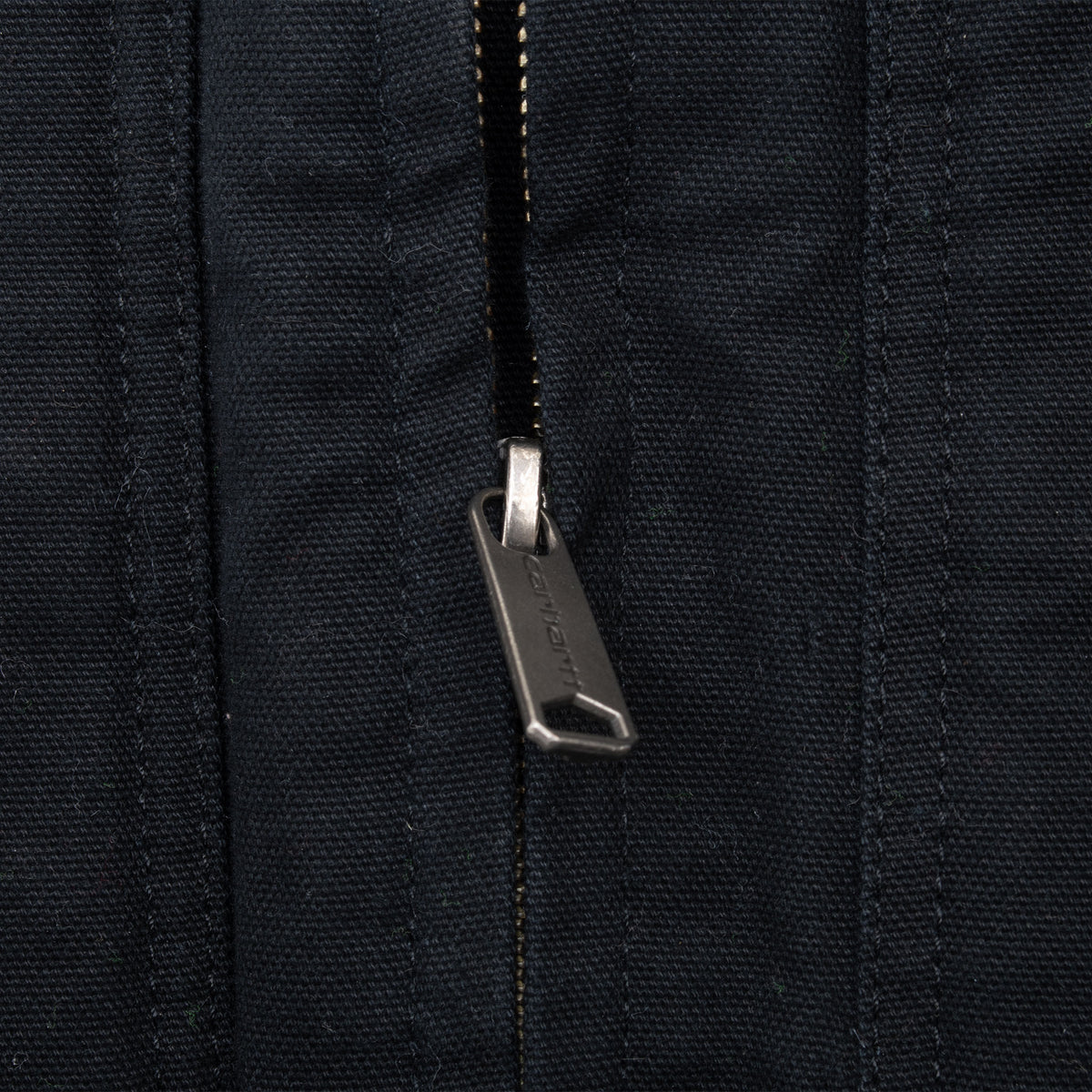 Close-up of Carhartt-branded zipper pull on black vest