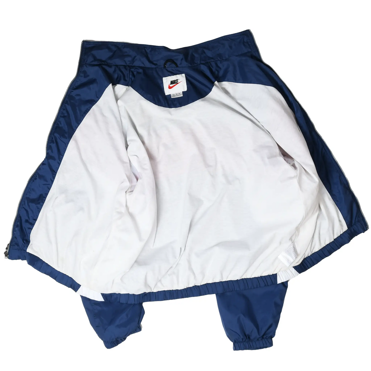Open Nike windbreaker showing white interior lining, navy collar, and neck label