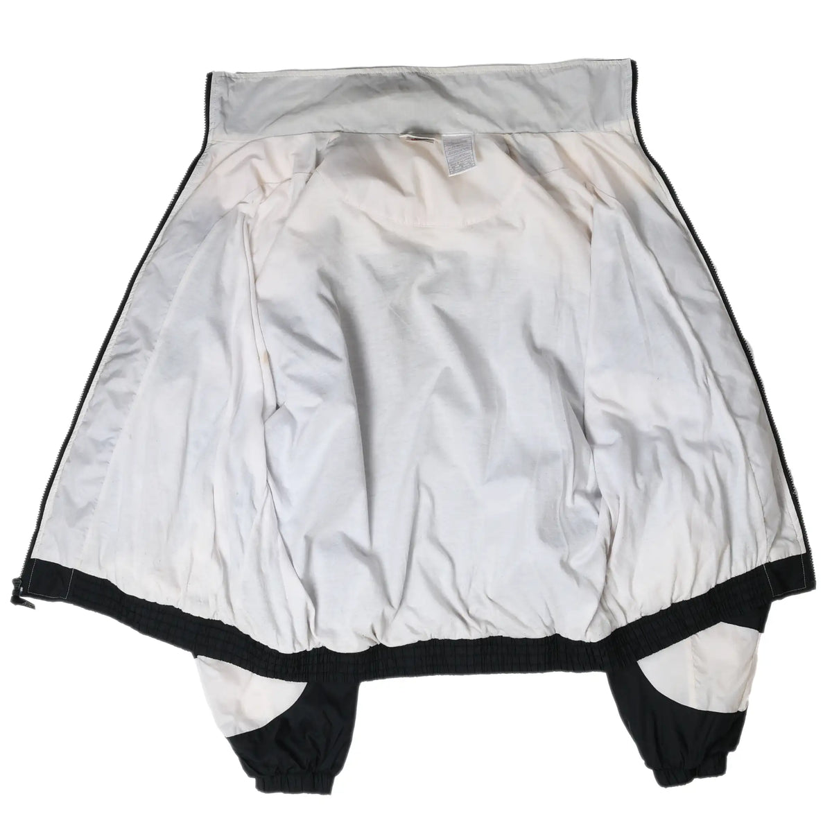 Open interior view of Nike windbreaker showing white lining, collar, sleeves, and elastic hem