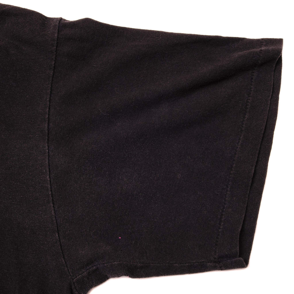 Close-up of black tee sleeve and single-stitch hem