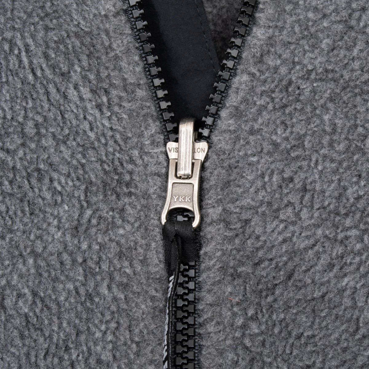Close-up of YKK front zipper on grey The North Face fleece jacket