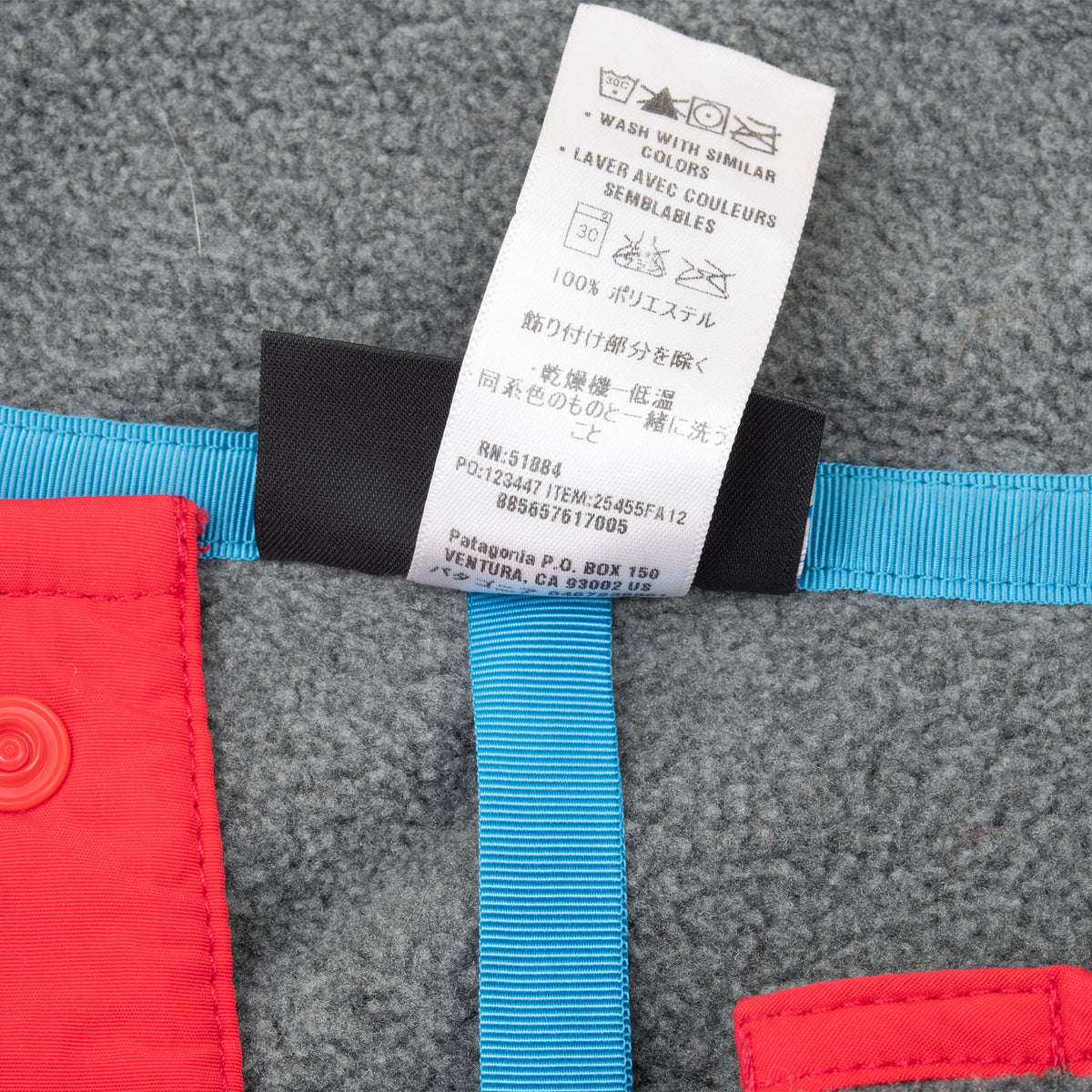 Care label detail inside grey Patagonia Synchilla fleece with blue and red trim