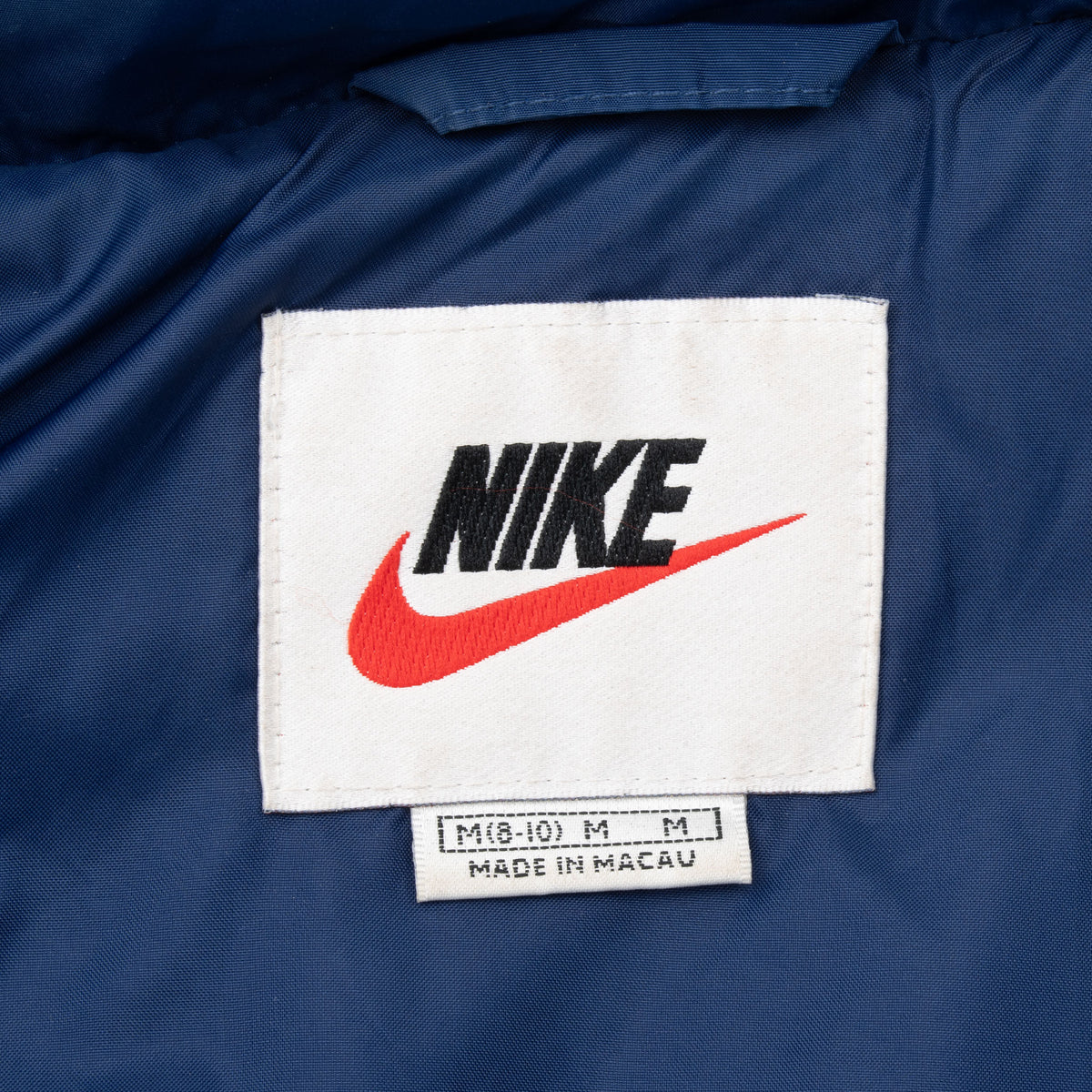 Nike neck label with black logo, red Swoosh and size M marking