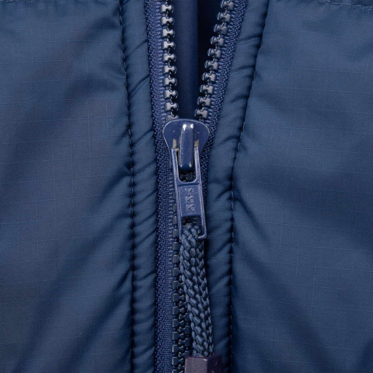 Close-up of the blue front zipper on the Nike puffer jacket