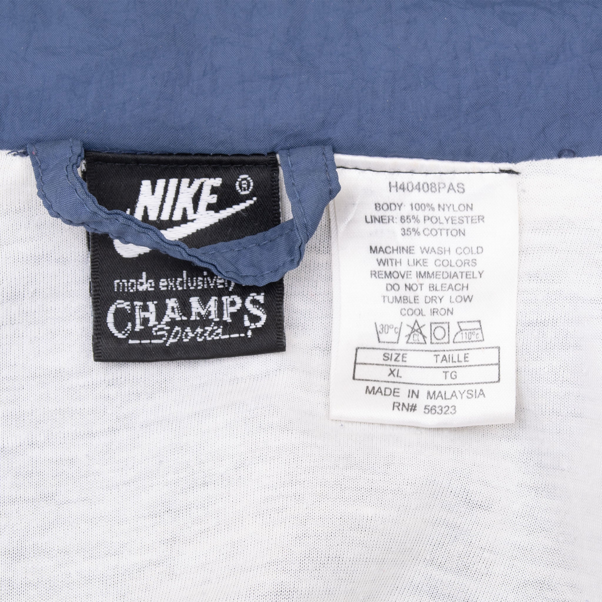 Nike Champs Sports neck tag and size XL care label inside blue windbreaker
