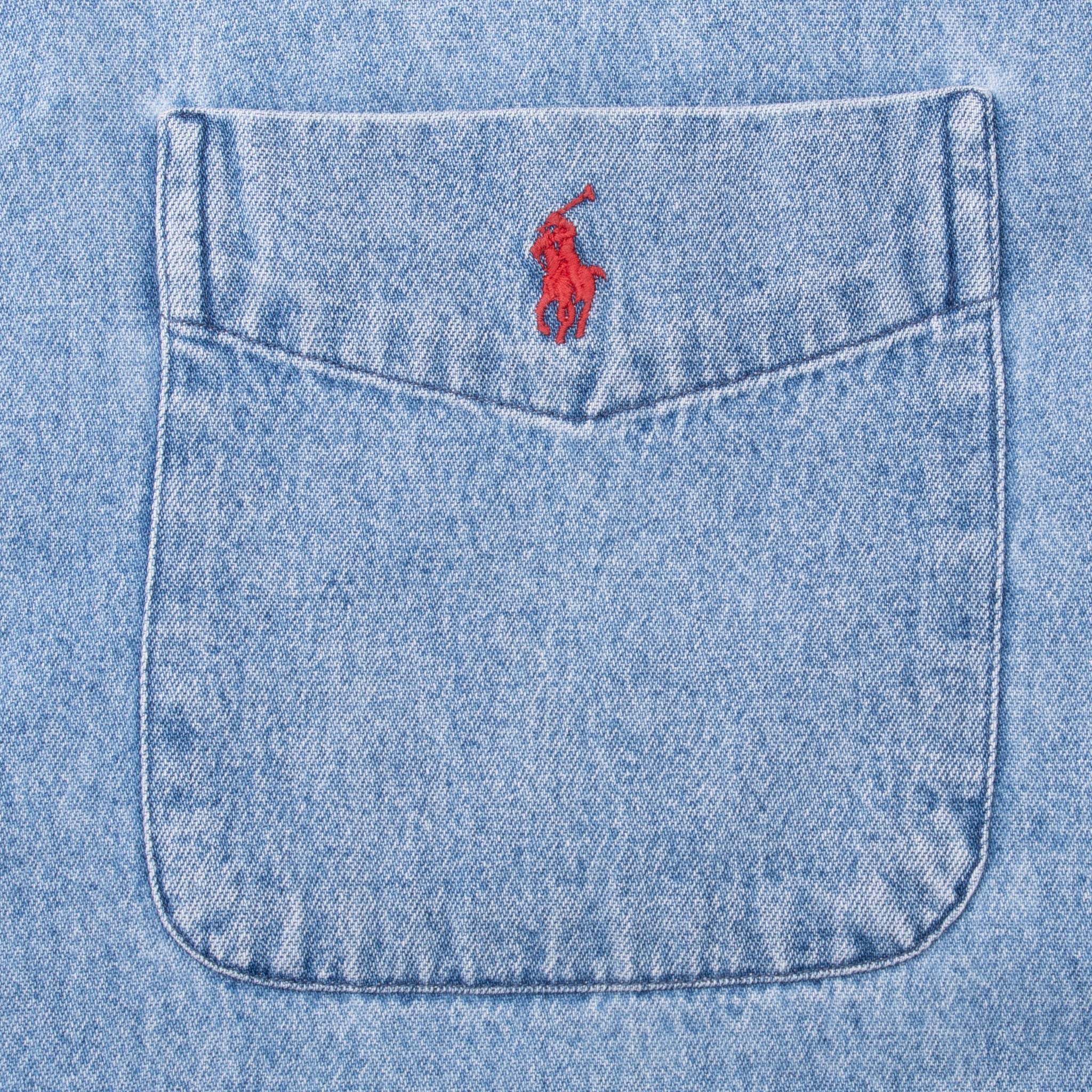 Blue denim chest pocket detail with pointed seam and red Polo pony embroidery