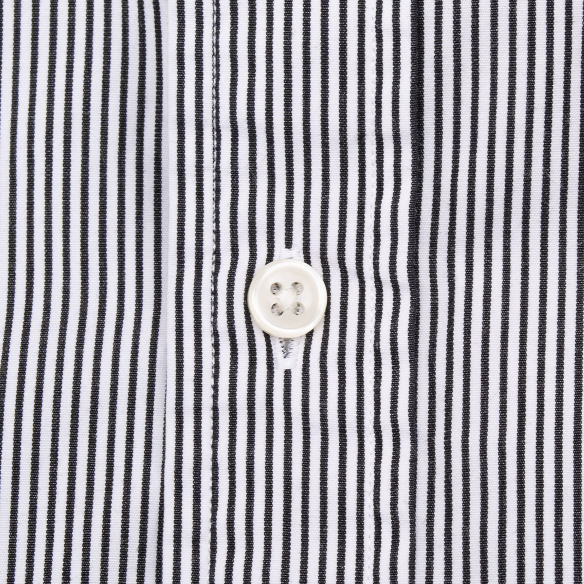 White four-hole front button detail on black and white striped shirt